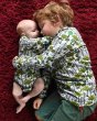 Young boy and baby cuddling on a red carpet wearing the DUNS organic cotton enchanted forest long sleeve top and long sleeve body suit