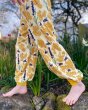 Close up of a childs legs walking on some rocks wearing the DUNS Sweden organic cotton bee yellow baggy pants