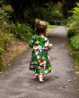 Young girl walking down a path wearing the DUNS organic cotton long sleeve gather skirt dress in the brown autumn leaves colour