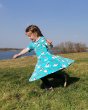 Girl running on some grass wearing the DUNS Sweden organic cotton skater dress in the blue puffin print