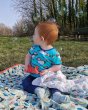 Young child sat on a blanket looking at bubbles wearing the DUNS Sweden short sleeve blue puffin top