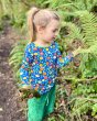 Child looking at some leaves wearing the DUNS Sweden organic cotton long sleeve top in the blue citrus print