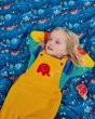 Girl laying on a Dan Y Ser Close playmat wearing the Babipur x Frugi organic cotton pluto cord dungarees in the gold colour
