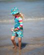 Young girl stood in the sea wearing the Frugi eco-friendly swimwear board shorts