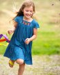 Girl running wearing the Frugi eco-friendly floral gemma chambray dress