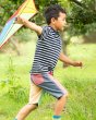 boy running through some grass with a kite wearing the Frugi eco-friendly hotch potch block shorts