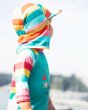 Young child turning backwards wearing the Frugi rainbow stripe swimming sun hat
