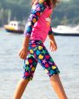 Close up of young child walking through some water wearing the Frugi eco-friendly two piece sun safe set in the seashells print 