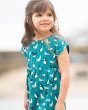Close up of young girl stood wearing the Frugi organic cotton sea birds fran jersey dress