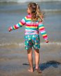 Young girl stood in the sea wearing the Frugi childrens eco-friendly boscastle board shorts