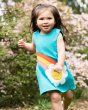 Young girl running in the Frugi turquoise daisy penny shift dress