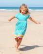 Girl running on the beach wearing the Frugi organic cotton sunset stripe fran jersey dress