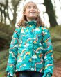 Young girl stood in the woods wearing the Frugi light blue rainbow print snow jacket