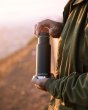 Close up of man holding the Klean Kanteen 12oz insulated drinks bottle at sunset