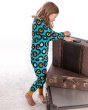 Girl stood next to some brown suitcases wearing the maxomorra childrens organic cotton classic lp pyjamas