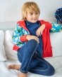 Boy sat on a white sofa wearing the Maxomorra organic cotton reversible zip hoodie in the pear print 
