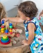 Close up of young child playing with some wooden toys wearing the Maxomorra organic cotton sky short dungarees