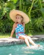 Girl sat on the side of a pool wearing the Maxomorra organic cotton anemone print jumpsuit