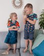 Boy and girl stood on a sofa wearing the Maxomorra short sleeve bulldozer top and tulip top