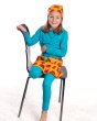 Girl sat on a black chair wearing the Maxomorra long sleeve turquoise top and the classic dino print skirt