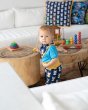 Young boy stood playing with wooden toys wearing the Maxomorra organic cotton dribble bib in the mouse print