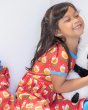Close up of a girl cuddling a fluffy toy wearing the Maxomorra organic cotton short sleeve spin dress in the tulip print