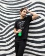 Man leaning on a striped wall holding a 500ml One Green Bottle plastic free reusable drink bottle 