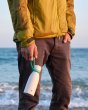 Man stood on the beach holding a One Green Bottle 350ml metal drinks bottle