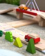 Red car driving along road on the Plan Toys Wooden Road set