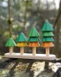 Close up of Plan Toys plastic-free Sort and Count Tree toy on a wooden log in a forest 