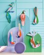 Studio Roof eco-friendly slotting paradise bird models hanging from purple, green and blue patterned panels