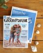 The Green Parent and Breath magazines on a wooden table next to a line of seashells