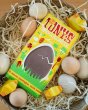 Tonys chocolonely fairtrade lemon merinque chocolate bar in a basket of straw surrounded by small wooden eggs
