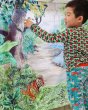 Young boy stood pointing to the Wonder Cloths large jungle playing cloth