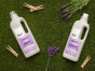 Bio D eco-friendly vegan lavender laundry liquid 1L bottle and conditioner 1 Litre bottle on a grassy background, surrounded by wooden pegs and purple lavender flowers