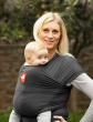 Woman carrying baby in the charcoal Hana baby carrier in front of a grey background
