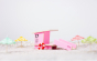 Candylab pink beach tower toy model on a sandy background next to some miniature umbrellas
