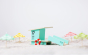 Candylab childrens wooden beach tower toy on some white sand next to some miniature umbrellas