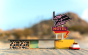 Close up of the Candylab wooden motel toy set on some sand in front of a large rock
