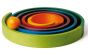 Naef wooden rainbow toy assembled in a flat, swirling pattern allowing small orange ball to roll in a circular motion along its groves.