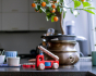 Bajo eco friendly wooden fire truck toy on a marble kitchen worktop in front of a metal flower pot