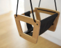 Close up of the Lillagunga plastic free oak wood toddler swing hanging in a living room