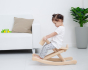 Toddler sat on the wooden foldable rocking horse by PlanToys. Side view.