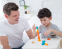 Adult and child playing the PlanToys stacking game together on a small table. 
