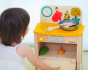 Child playing with the PlanToys Wooden Play Kitchen Set, opening the oven door.