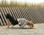 Woman laying on a Wobbel XL Beech Wood balance board on some grey outdoor tiles