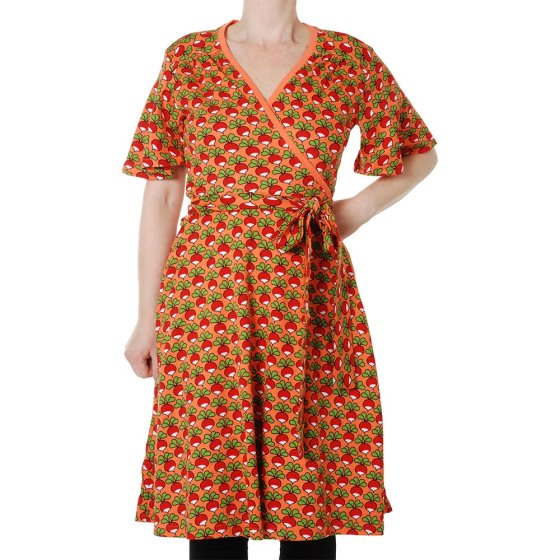 Woman stood on a white background wearing the DUNS Sweden flutter sleeve wrap dress in the camelia radish print