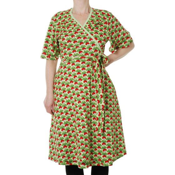 Woman stood on a white background wearing the DUNS Sweden flutter sleeve wrap dress in the paradise green radish print