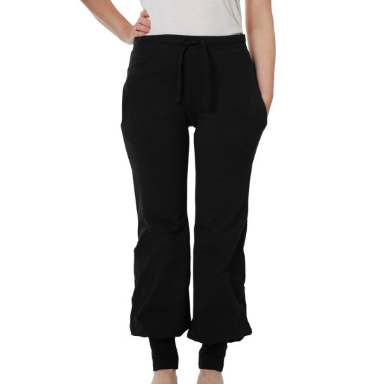Woman wearing the organic cotton DUNS more than a fling black baggy pants on a white background