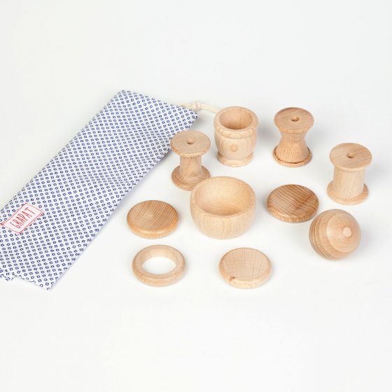 Grapat 10 Wooden Elements Treasure Basket, 10 natural wood elements and organic cotton storage bag, including bobbins, cups, balls and coins for ages 10 months+. Perfect for heuristic play. White background.